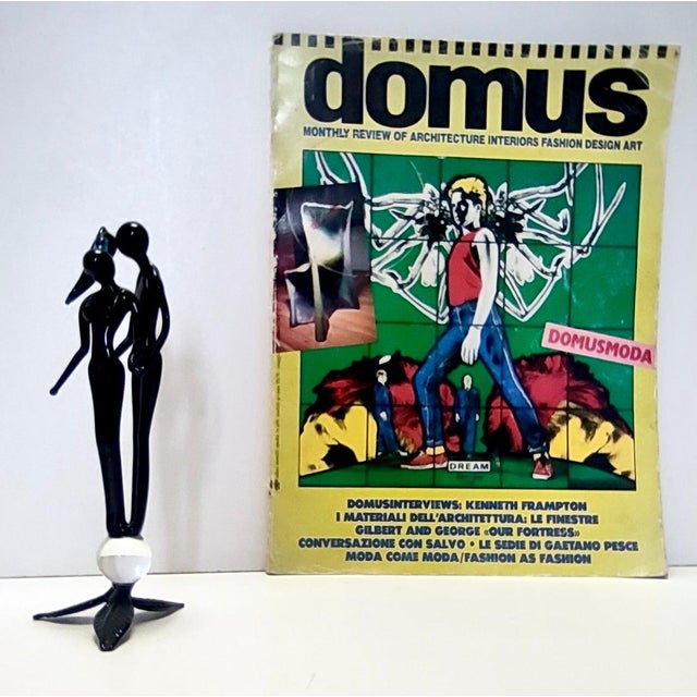 Made in Italy, 1990s. This black Murano glass couple with a cyan detail in her ponytail looks like it's floating on a...