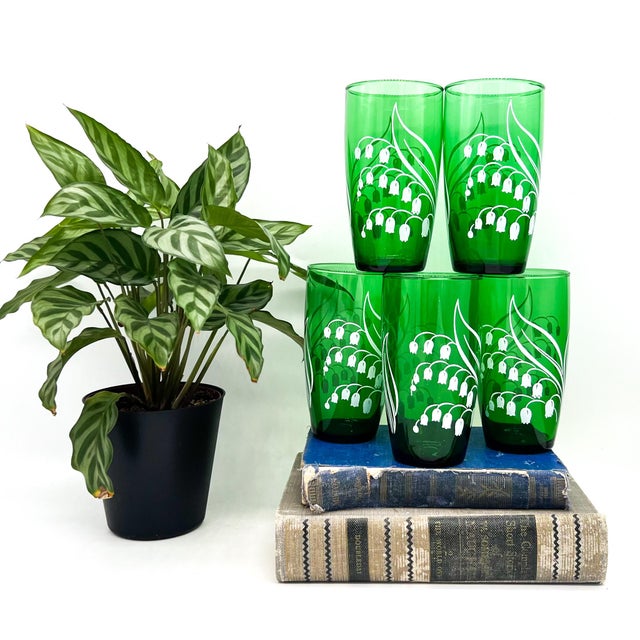 Charming set of 5 botanical tumbler glasses featuring a delicate white “Lily of the Valley” motif set against rich forest...