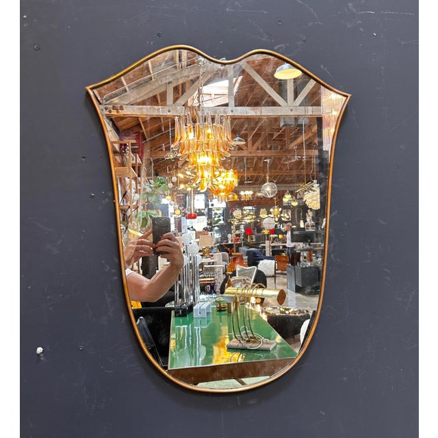 "An alluring vintage Italian curvilinear brass wall mirror from the 1980s, showcasing distinctive design and...