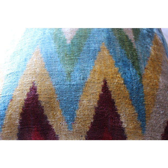 Bohemian silk velvet ikat pillow with vibrant colors of red, beige and blue. Super hand soft. Pillow has a zipper for...