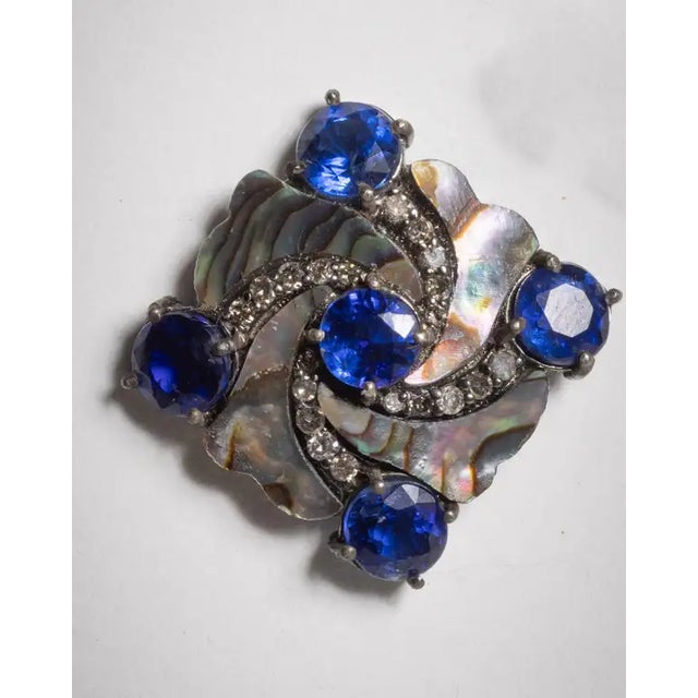 A very unusual pair of stud earrings comprised of abalone shell, round faceted kyanite gemstones and rays of round faceted...