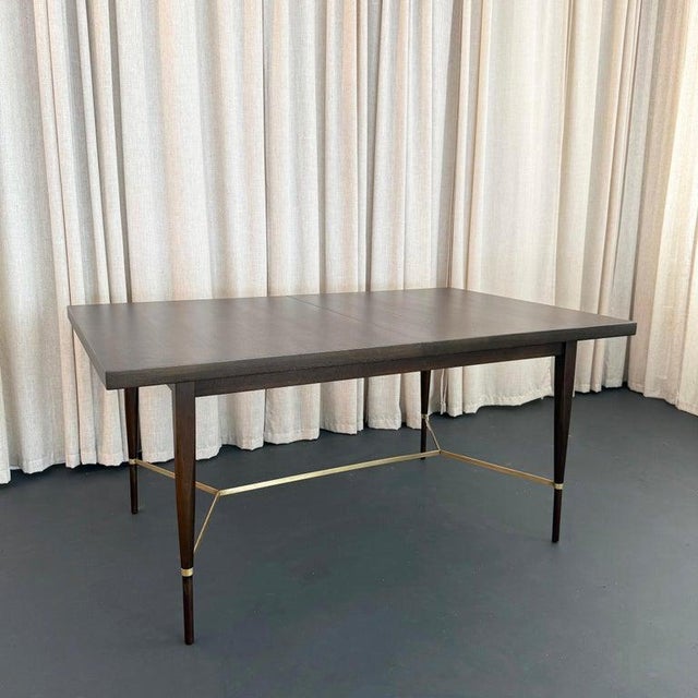 This Mid-Century Modern, mahogany and brass, extension dining table was designed by Paul McCobb for Calvin Furniture’s...