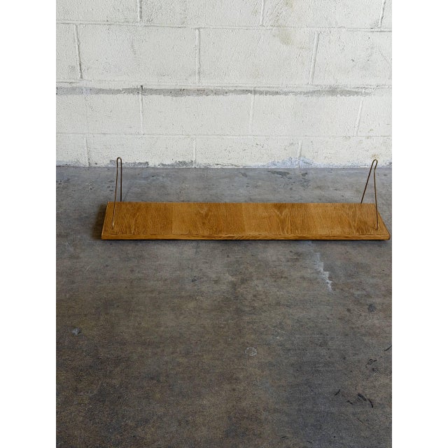 Beautiful vintage Danish wall shelf crafted in oak with minimalist brass-tone metal brackets. This elegant Scandinavian...