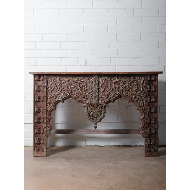This stunning hand-carved wooden console table showcases exquisite craftsmanship and richly detailed floral motifs...