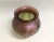 A Czech Republic Bohemian art glass vase in hues of purple, green and gold. The iridescent rose bowl is hand blown and...