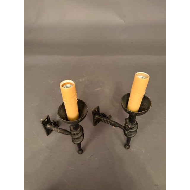 Pair of 19th-century French hand-wrought iron wall sconces dating to circa 1890. Each sconce features an elongated,...