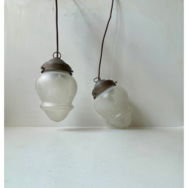 A matching pair of Edwardian styled Pendant lamps executed in patinated copper and featuring hand-made etched glass...