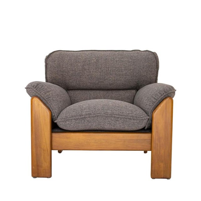 A pair of armchairs with a solid wood frame, handcrafted and upholstered in taupe wool.