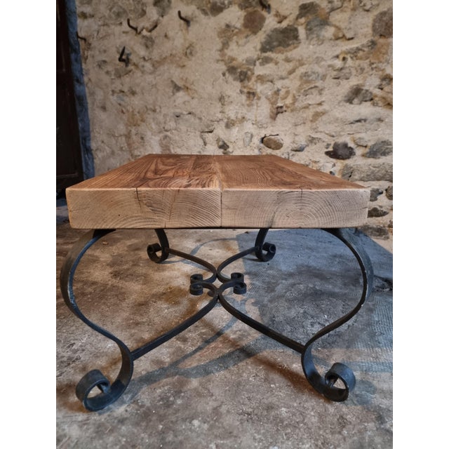This vintage French coffee table dates from the 1960s and features a rustic pine tabletop combined with a decorative black...
