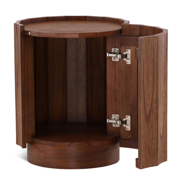 Rich brown Mindi wood round side table with smooth scalloped design. Subtle door opens up for storage space option inside...