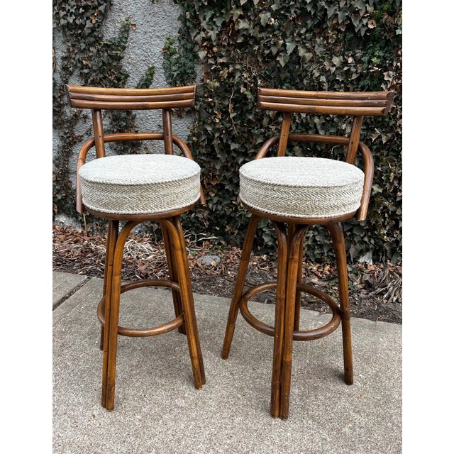 Gorgeous three strand rattan bar stools with arch armrests and legs. These unique vintage bamboo stools in the style of...