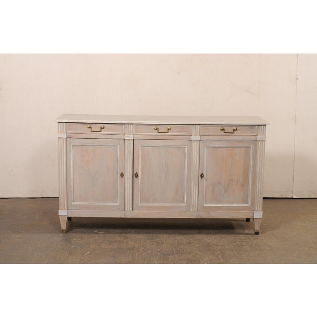 A painted wood French buffet cabinet from the turn of the 19th and 20th century. This antique storage cabinet from France...