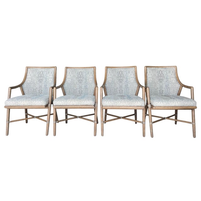 Set of four McGuire Passage dining armchairs featuring sculpted rattan frames with signature rawhide lashings and woven...