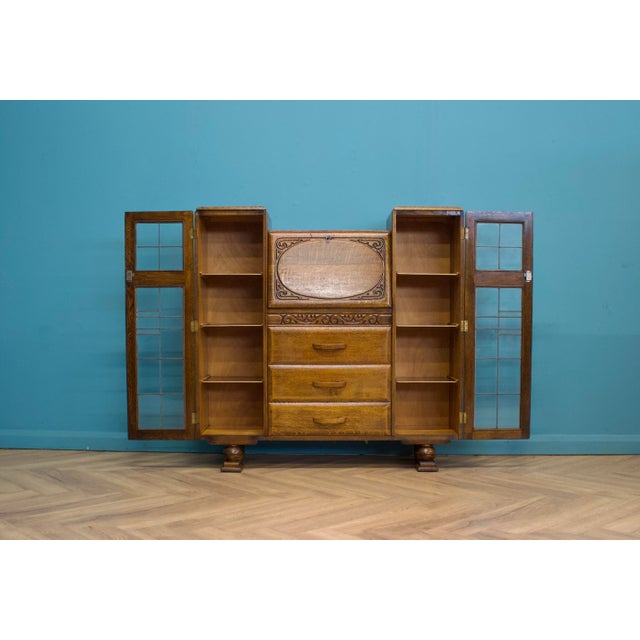 A 1930s Art Deco oak bureau bookcase with beautiful tiger grain and warm colour throughout. The carved fall-front bureau...