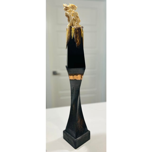 Dragon sculpture featuring carved fossil walrus material figure, mounted on a decorative pedestal display. This piece...