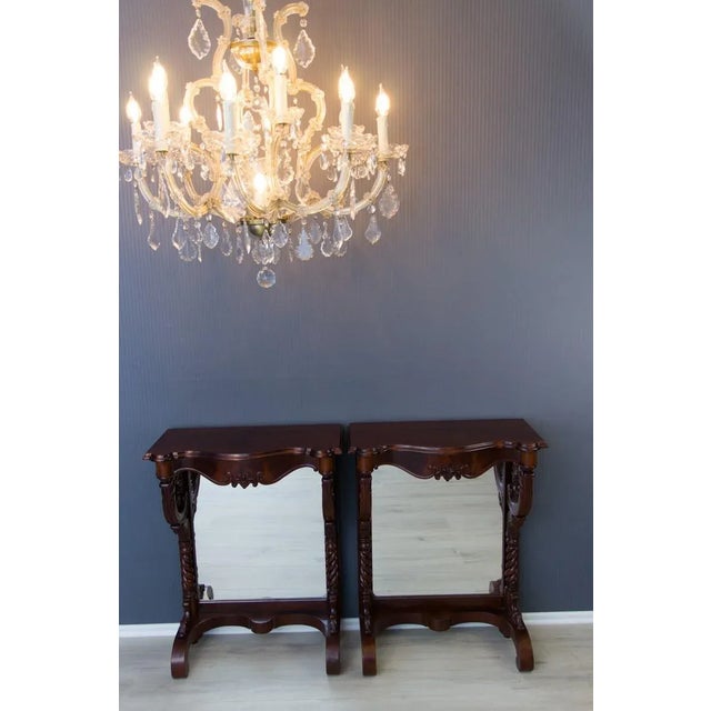 - Pair of Regency style walnut wall console tables - Raised on carved scrolling supports with mirrored back panels. - Legs...