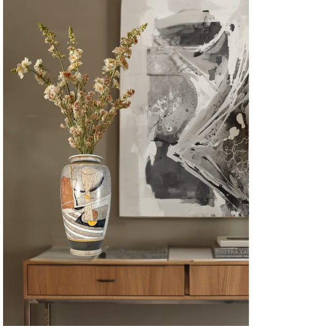 This large ceramic statement vase stands 13 1/2 inches tall and measures eight inches at its widest point, presenting a...