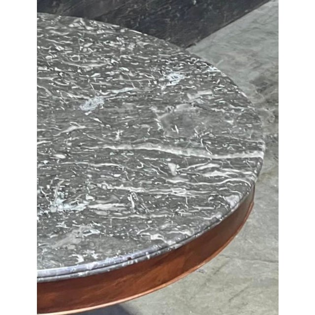 A lovely French Gueridon Table dating to the mid 19th Century. Variegated Grey original marble top with mahogany Base. In...