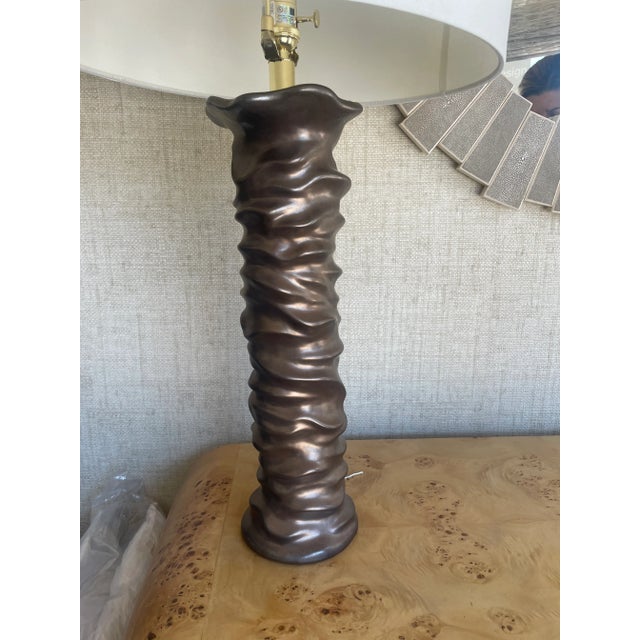 Ceramic organic bronze table lamp with off-white linen shade and gold hardware. Perfect as a tall accent for contemporary...