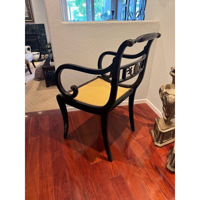 A sophisticated Regency-style ebonized armchair manufactured by the renowned Robert W. Irwin Company of Grand Rapids,...