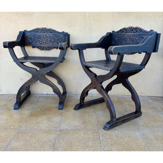 Beautiful pair of Spanish Renaissance Revival Savonarola chairs, crafted in solid wood and richly carved with scrolling...