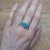 A rare boulder opal rests in a play of colour across ironstone at the centre of this solid 14K white gold ring, surrounded...