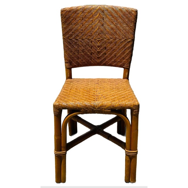 A set of four 1970's bamboo and woven rattan dining chairs. Bamboo was used to construct the chair frames, while woven...