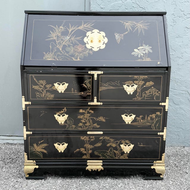 Striking vintage Chinese secretary desk featuring a glossy black lacquered finish with intricate hand-painted gilt...
