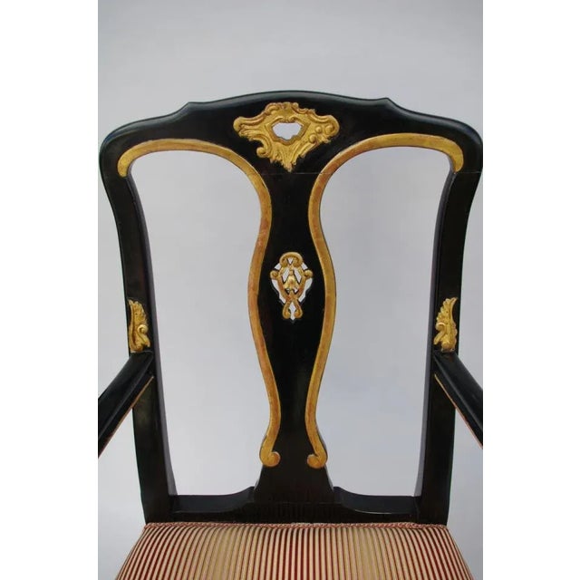 Pair of Chippendale style carved and black lacquered wood armchairs standing on two back saber legs and two front claw and...
