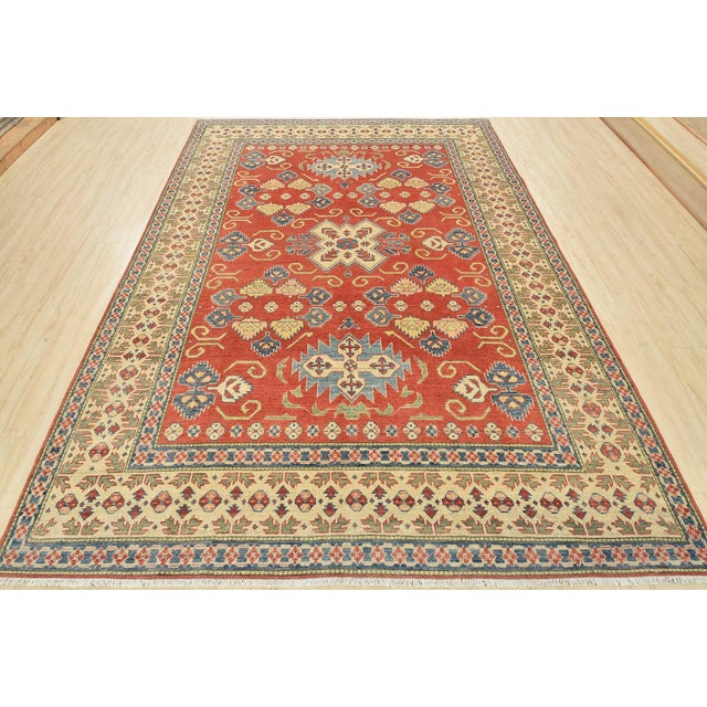 A traditional tribal Caucasian Kazak rug hand-knotted with an all-wool pile on a cotton foundation. This oriental rug...