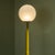 This Postmodern floor lamp was produced in Italy in 1970. It features a tall stem lacquered with a mustard/ocher color....