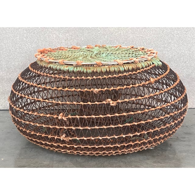 Wire cage with feet. Used for transporting shell fish. Fun and rare. Multiples available. Used like a lamp or side table...