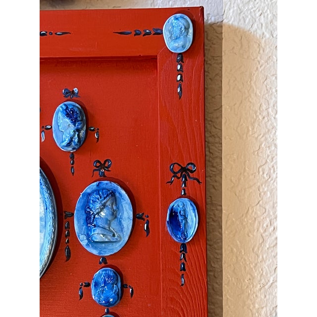 A rare grand tour style blue Faience glazed plaster cameo arrangement. Red painted sunken frame and blue hand painted...