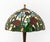 Tiffany Studios Style Stained Glass Table Lamp, bronzed patinated metal base with three bulb fittings below a tulip flower...