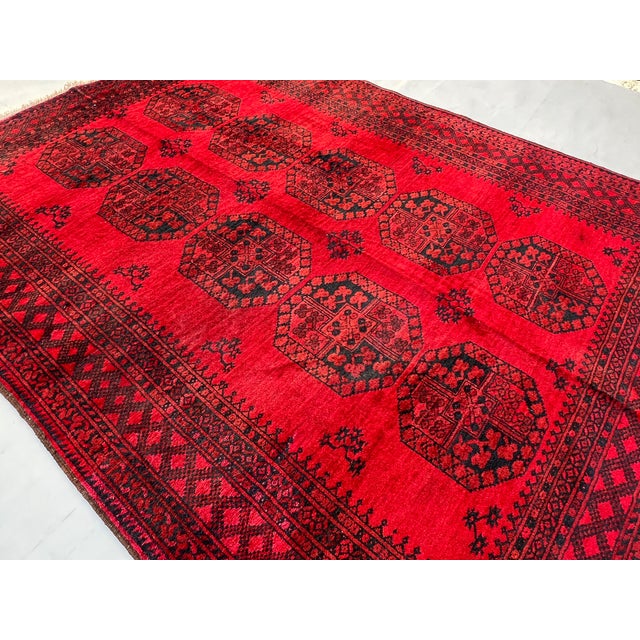 A bold vintage Afghan Khal Mohammad Bokhara tribal rug featuring two columns of five large octagonal "Aina" (mirror) guls...