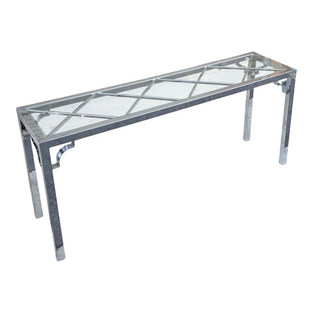 Sleek and sophisticated, this vintage chrome and glass console table brings a touch of Hollywood Regency glamour to any...