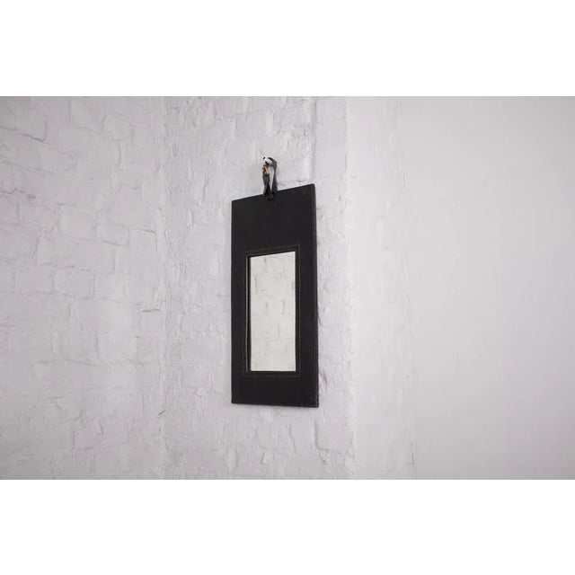 In the taste of jacques adnet, rectangular mirror, sheathed in black leather stung to the point of saddler. French work...