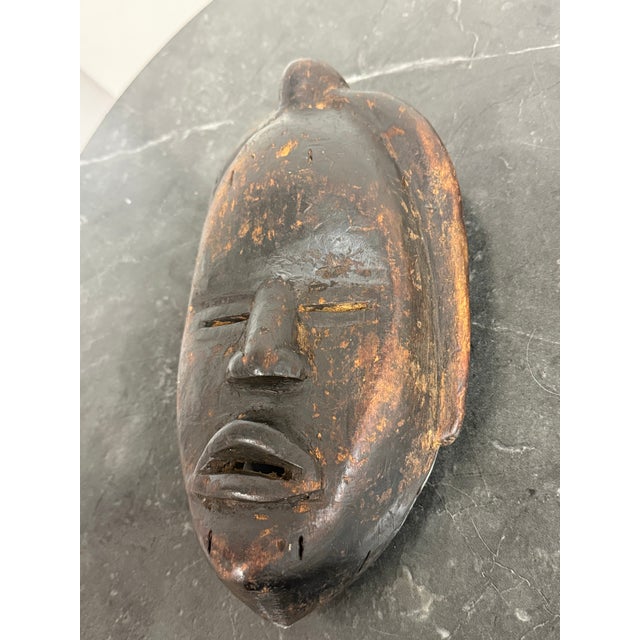 Design Plus Gallery presents a West African Dan Tribe Carved Wood Mask. Carved from wood, the mask has an elongated oval...