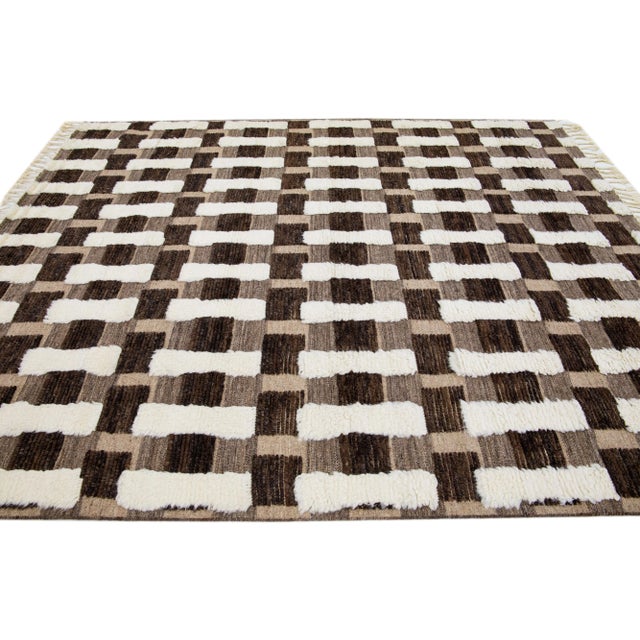 This handcrafted wool rug features a modern Moroccan design in a soothing Ivory hue, skillfully contrasted against a...