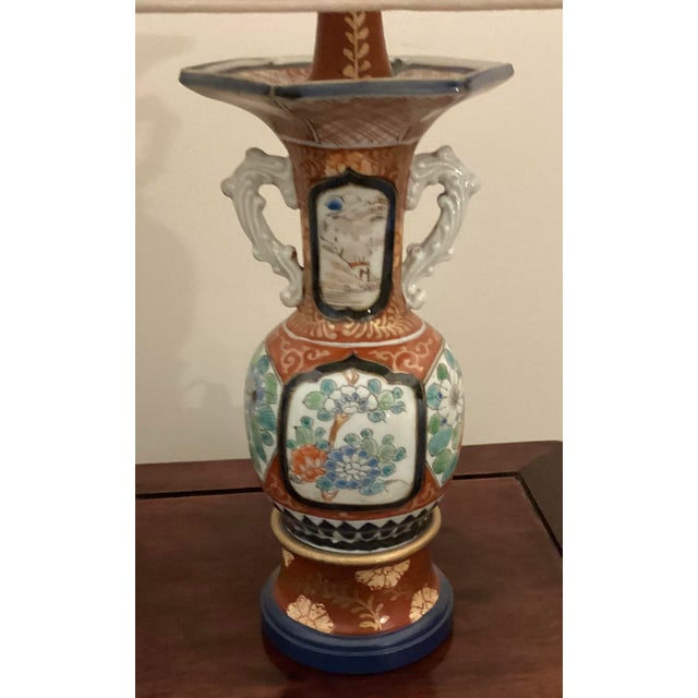 Vases have a hexagon shaped mouth and prominent, stylized twin ear handles on each side of the vase. The hand painted...
