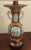 Vases have a hexagon shaped mouth and prominent, stylized twin ear handles on each side of the vase. The hand painted...