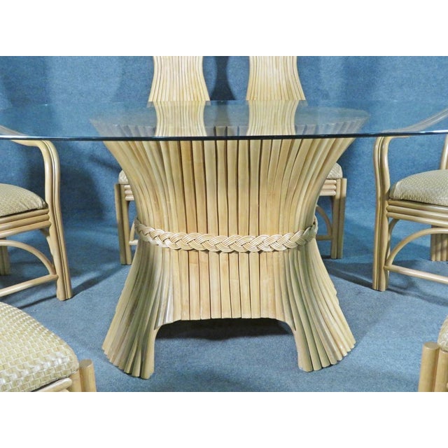 Odd rattan bases with woven faux leather seats with high backs. Table has rattan base with oval glass top. 2 arm chairs...