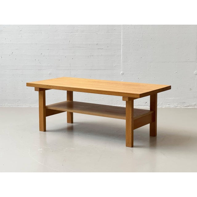 A simple coffee table made of solid oak with a clean, functional design in the style of scandinavian mid-century modern....