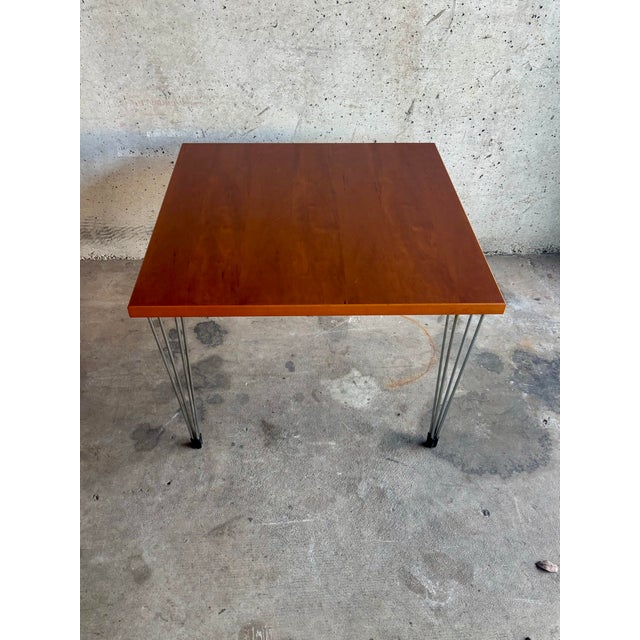 A minimalist side table designed and produced in Holland during the 1970s, combining a warm beech wood top with slender...