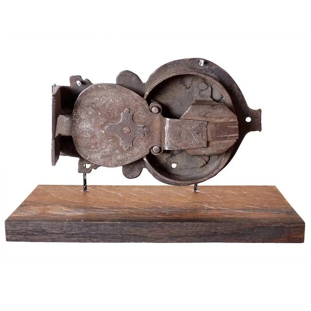 An antique, hand forged iron European lock with ornate, chased decoration on a custom stand. Notice the fine etched line...