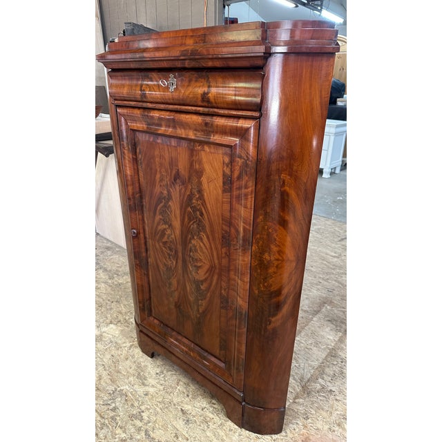 Corner mahogany Biedermeier cabinets like this one became popular in the 18th and 19th centuries as a way to maximize...