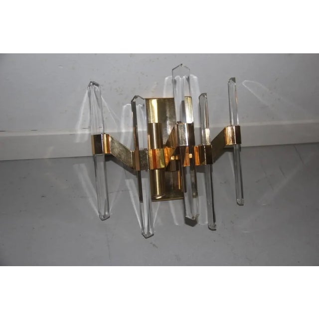This Sciolari sconce of minimal design is made of gilt brass. Up to 250V (Europe/UK Standard).The wiring of this item may...
