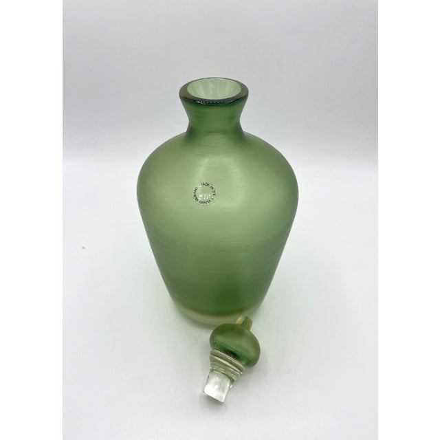 Bottle from the Incisi series designed by Paolo Venini for the Venini glassworks. This green bottle with a heavy stopper...