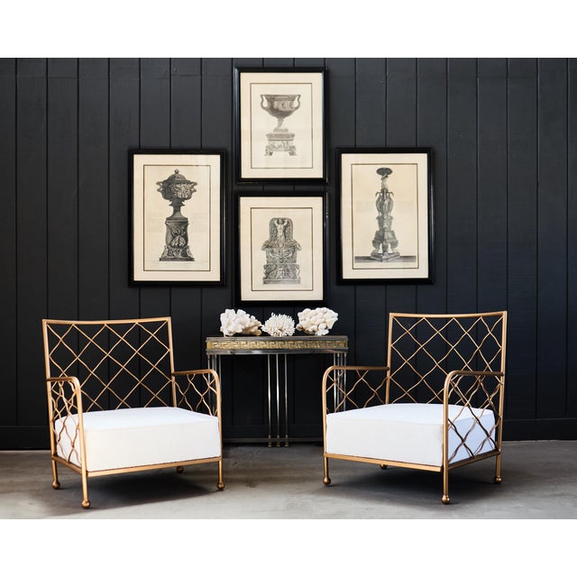 Sublime pair of mid-century modern French Maison Jean Royere style gilt iron Crosillion lounge chairs or armchairs. The...