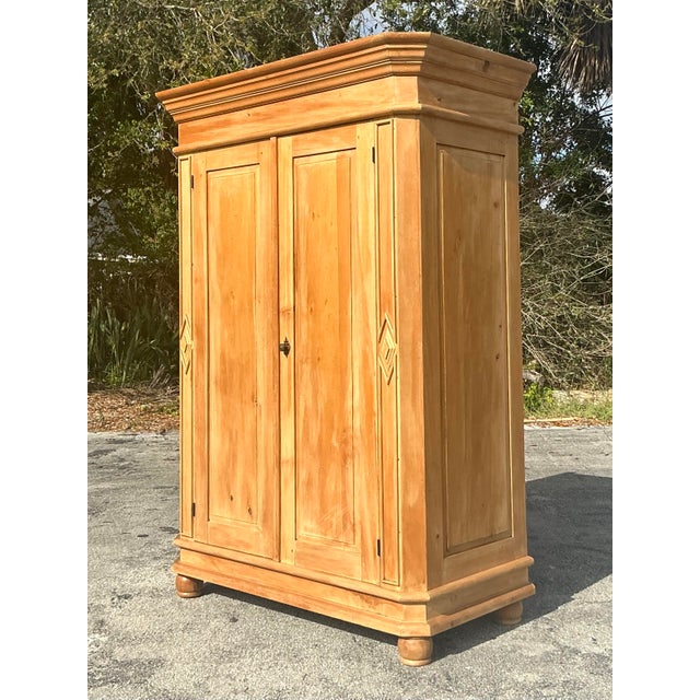 Bring warmth and character to your space with this beautifully crafted vintage boho washed pine armoire. Featuring a...